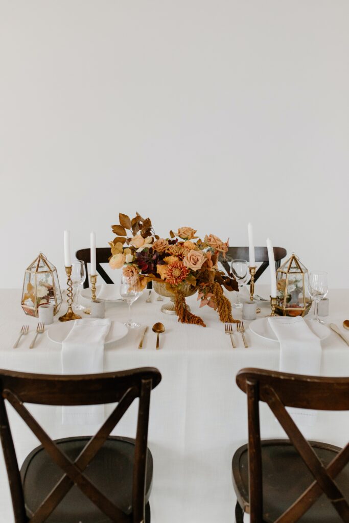 dining table with white table cloth and fall inspired floral arrangements. Interior decorators in wayzata